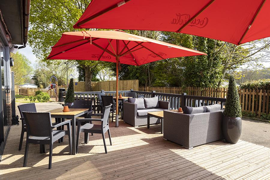 shaded outdoor seating area at Coghurst Hall Holiday Park