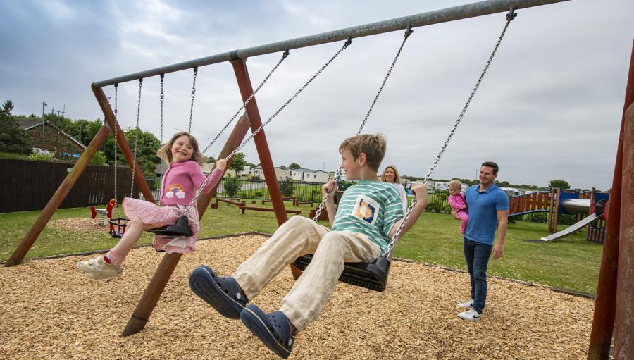 on the swings outside at Withernsea Sands Holiday Park