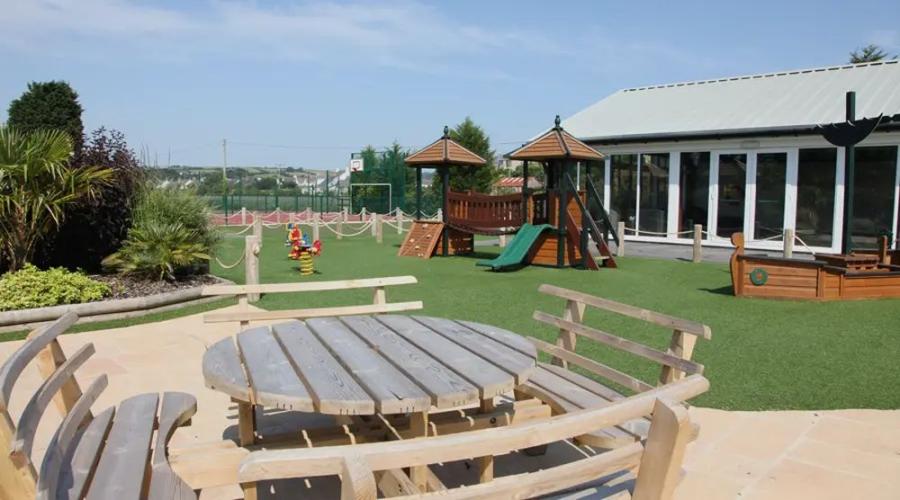 playground and outside eating space at Par Sands Coastal Holiday Park