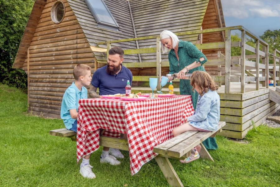 having a meal by a glamping pod at Royal Umpire Holiday Park