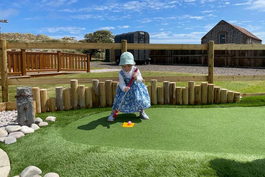 chldren playing crazy golf on holiday at Waxham Sands Holiday Park